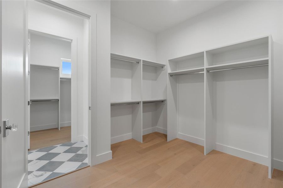 One of two custom walk-in closets with built-in shelving and exceptional storage space.