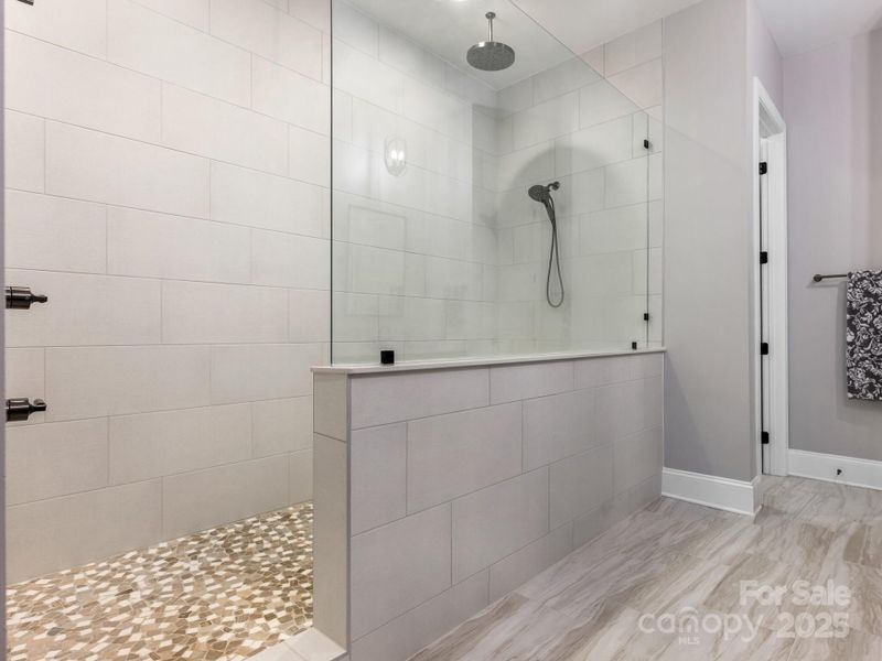 1st Flr, Primary Bath, large walk-in shower, w/river rock basin, floor to ceiling tile, rain shower and hand held shower head.