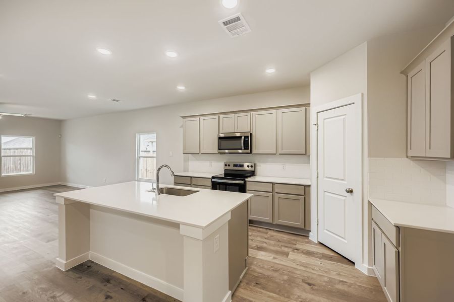 A kitchen with white cabinets.