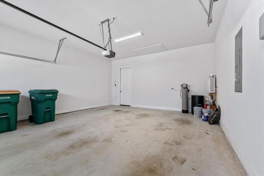 View inside two car garage with a water softner systen and a tankless water heaater.