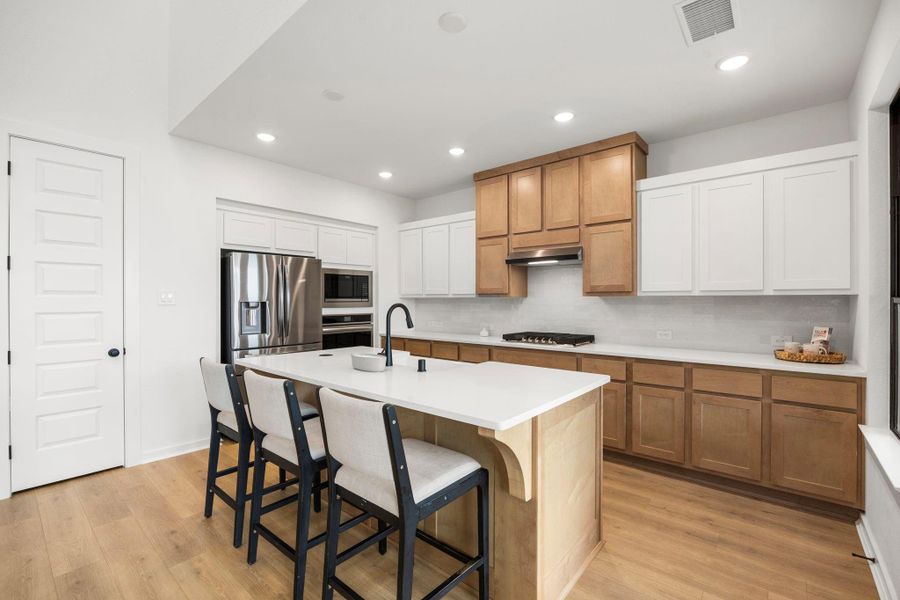 The kitchen has a large island with a large white farmhouse sink.