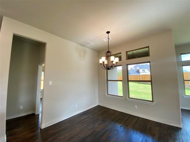 Kitchen cafe with windows overlooking very large yard and decorative chandelier.