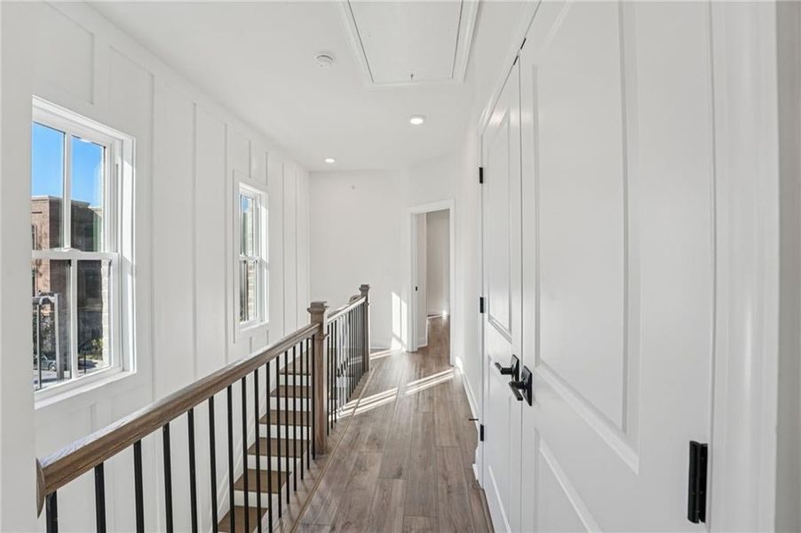 Hallway with attic access, dark wood-type flooring, recessed lighting, and an upstairs landing Hallway with attic access, dark wood-type flooring, recessed lighting, and an upstairs landing
