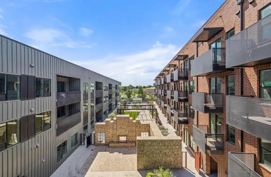 Industrial chic brick and metal facades flank a central courtyard featuring an outdoor fireplace. Industrial chic brick and metal facades flank a central courtyard featuring an outdoor fireplace.