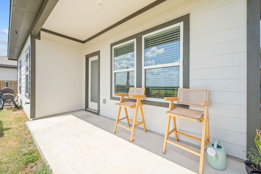 An inviting covered concrete patio provides a serene outdoor space directly off the home.