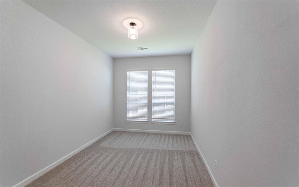 Room featuring neutral-toned walls, patterned carpet flooring, and a pair of windows with horizontal blinds Room featuring neutral-toned walls, patterned carpet flooring, and a pair of windows with horizontal blinds