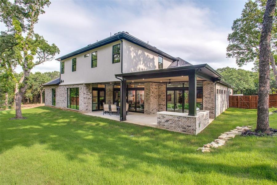 Rear view of property with a lawn, a patio area, and ceiling fan