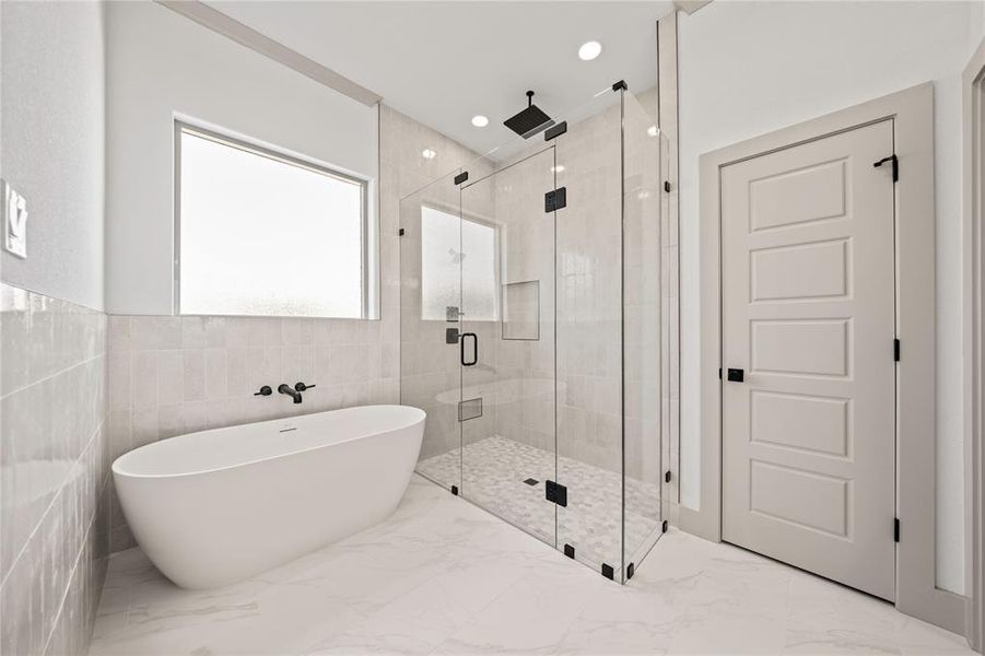 Bathroom featuring a stall shower, a freestanding bath, marble tiled flooring, and recessed lighting Bathroom featuring a stall shower, a freestanding bath, marble tiled flooring, and recessed lighting