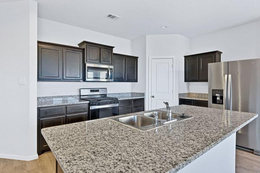 Kitchen island has granite counters and a stainless steel sink Kitchen island has granite counters and a stainless steel sink