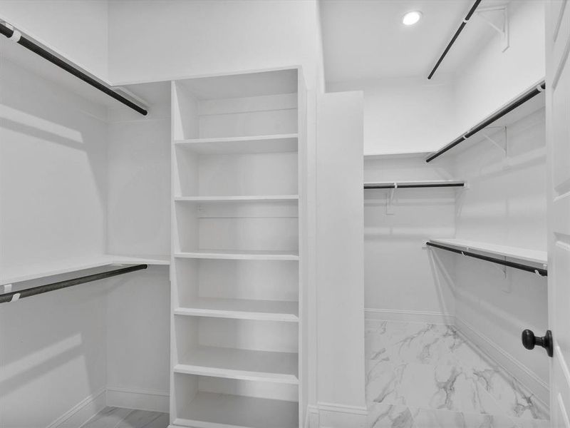 Walk in closet with light marble finish flooring