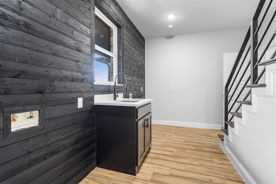 Kitchen featuring wood walls and sink