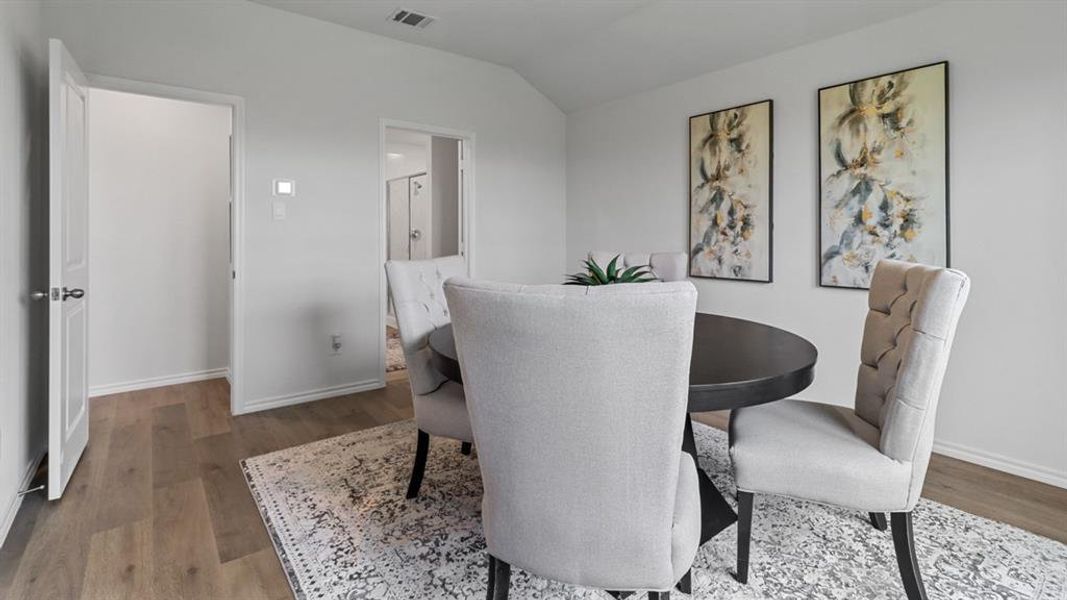 Dining area featuring lofted ceiling and wood finished floors Dining area featuring lofted ceiling and wood finished floors