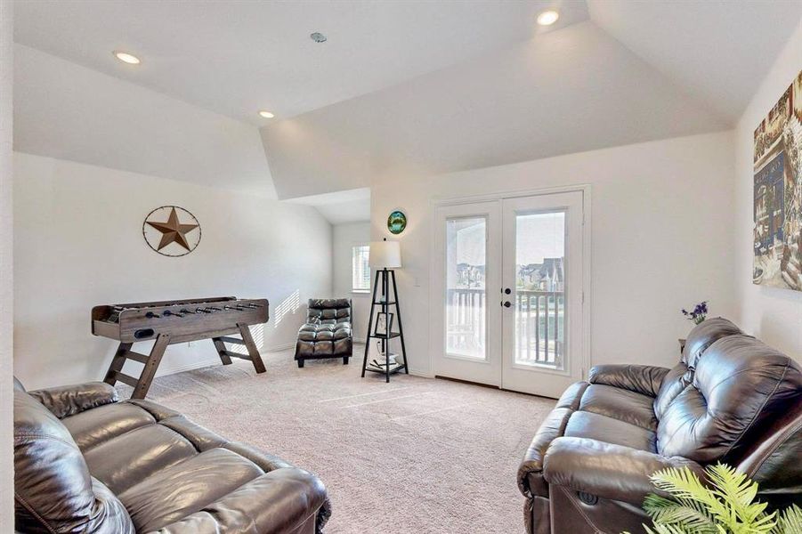 Living room featuring light carpet, french doors, lofted ceiling, and recessed lighting