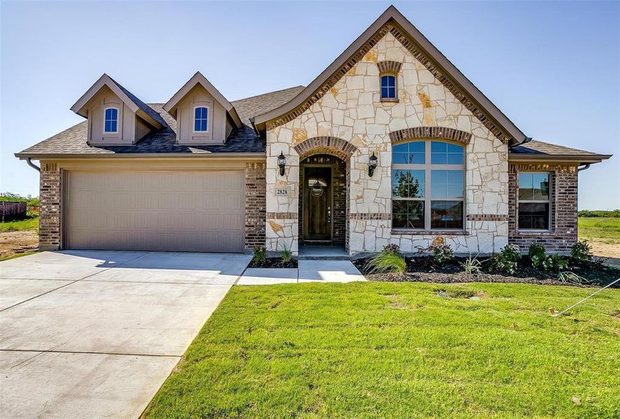 View of front of home featuring a front lawn and a garage