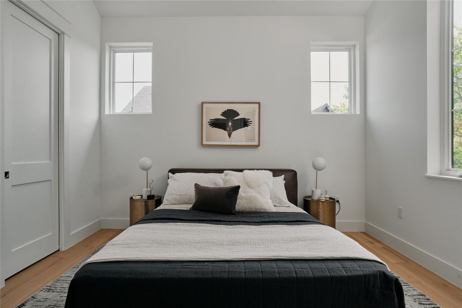 Bedroom with light wood-type flooring and baseboards Bedroom with light wood-type flooring and baseboards