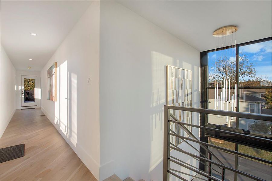 Corridor with light hardwood / wood-style flooring and floor to ceiling windows