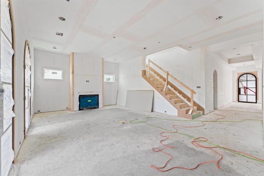 The expansive living room is adjacent to and adjoining the kitchen. The room features a 42" modern gas fireplace and arched steel French doors.