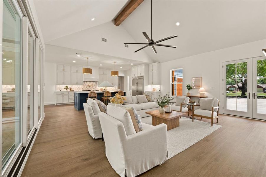 Living area featuring french doors, beamed ceiling, wood finished floors, a ceiling fan, and recessed lighting Living area featuring french doors, beamed ceiling, wood finished floors, a ceiling fan, and recessed lighting