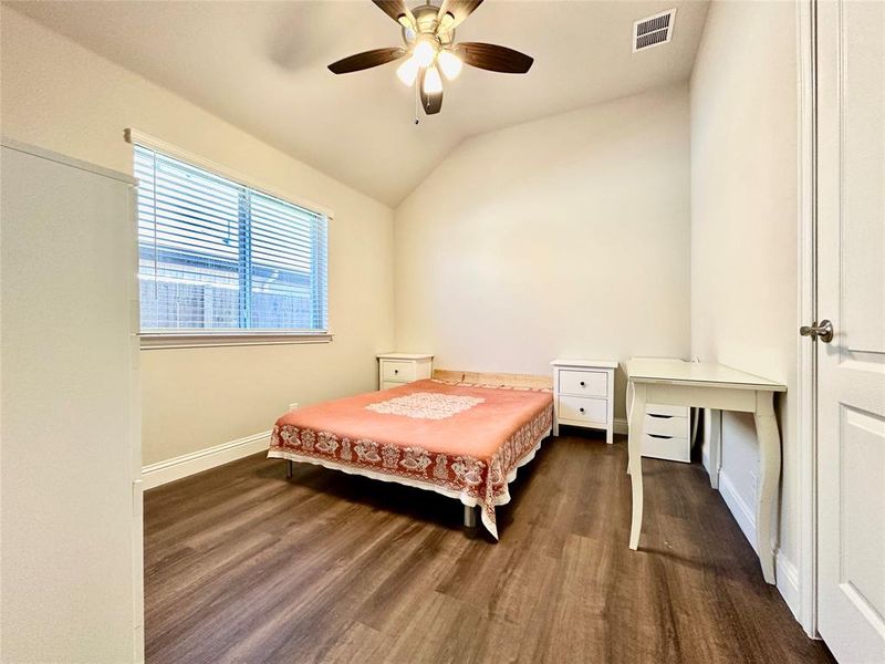 Bedroom with ceiling fan, vaulted ceiling, and dark wood-type flooring