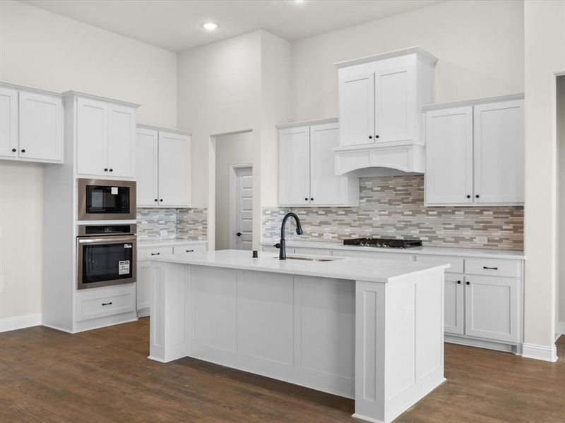 Kitchen featuring stainless steel oven, white cabinetry, built in microwave, dark wood finished floors, and decorative backsplash