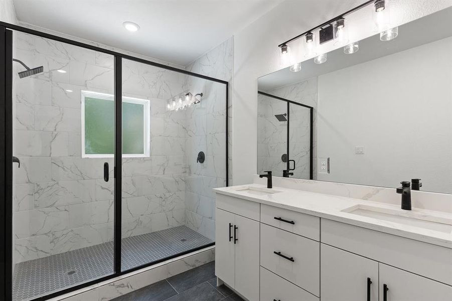 Full bath featuring a marble finish shower and double vanity Full bath featuring a marble finish shower and double vanity