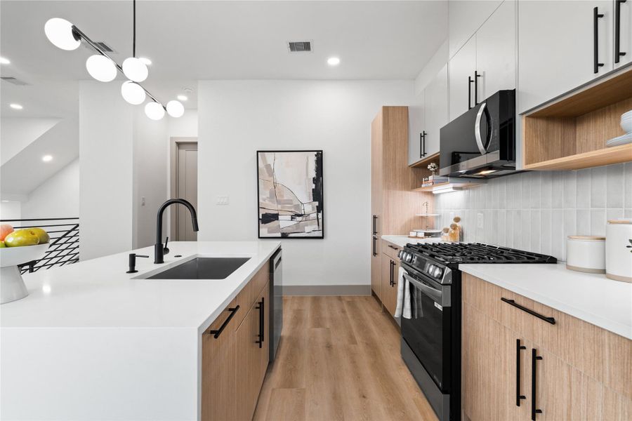 Clean lines and clever design come together in this stunning galley-style kitchen, where flat-front cabinets, matte black hardware, and a gas range elevate the everyday. With open shelving and a waterfall island, this space is equal parts function and finesse—ready to handle everything from weeknight dinners to weekend brunches. Clean lines and clever design come together in this stunning galley-style kitchen, where flat-front cabinets, matte black hardware, and a gas range elevate the everyday. With open shelving and a waterfall island, this space is equal parts function and finesse—ready to handle everything from weeknight dinners to weekend brunches.