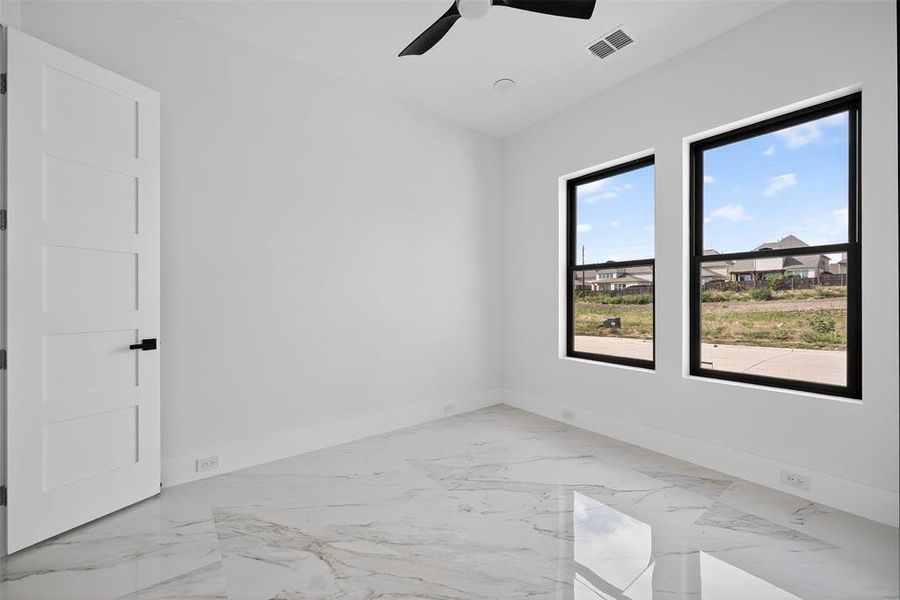 Empty room with light marble finish floors and ceiling fan