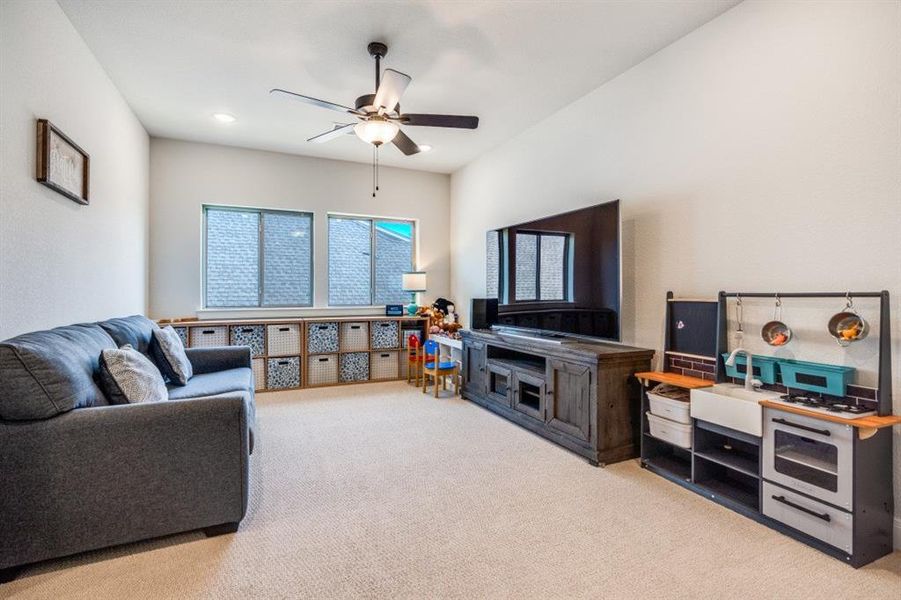 Living room featuring light carpet and ceiling fan