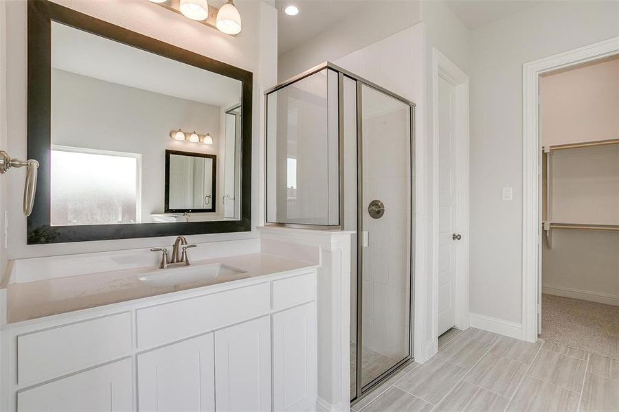 Bathroom featuring a shower with door and vanity