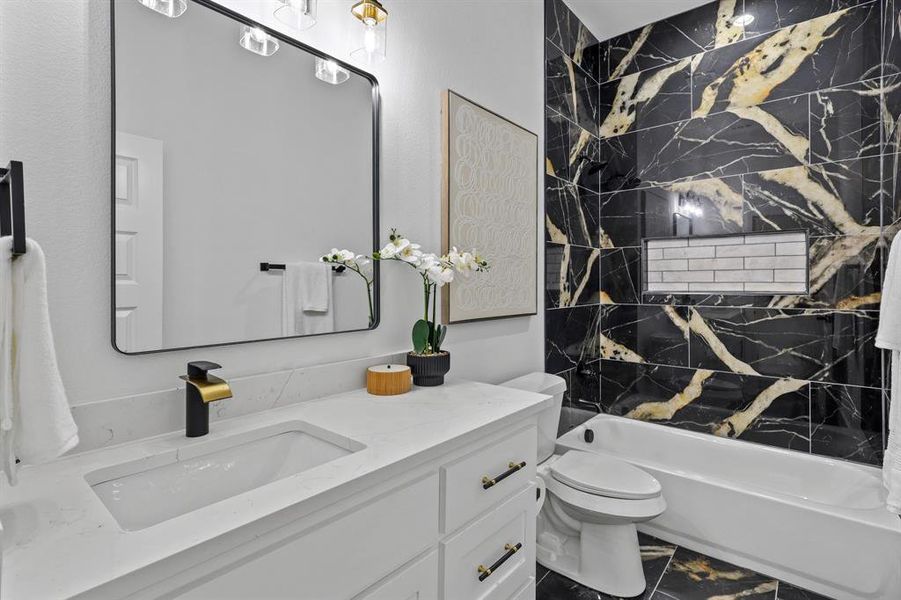 Full bathroom featuring vanity, toilet, and tiled shower / bath