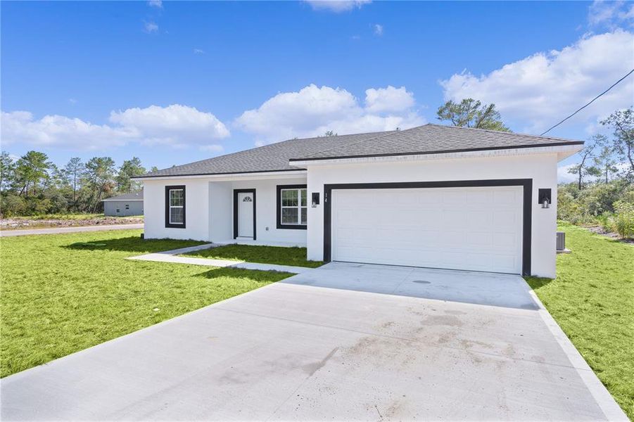 2-car garage with concrete driveway and font walkway