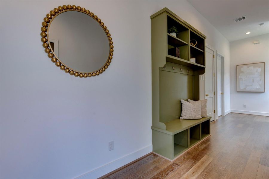 Beautiful large entryway with ample natural light and elegant  built-in décor with hooks and shelves for storing coats, etc.