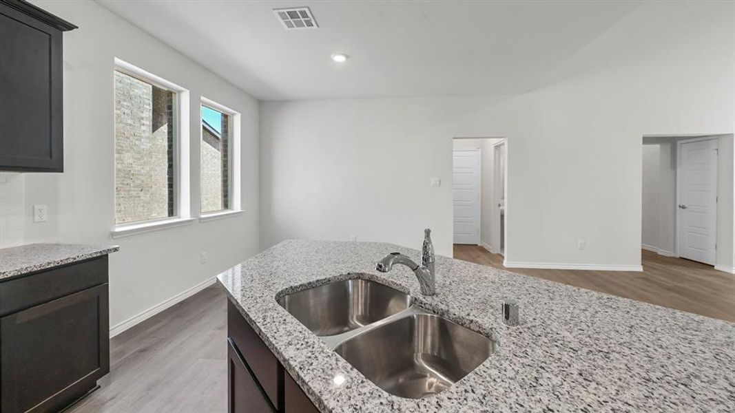 Kitchen featuring light wood finished floors, light stone countertops, and recessed lighting