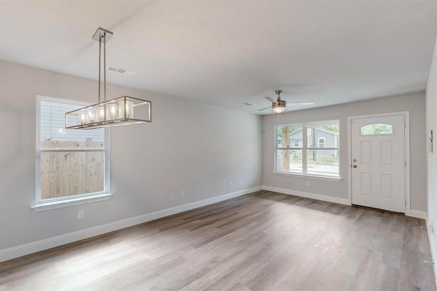 Foyer featuring ceiling fan with notable chandelier and light hardwood / wood-style flooring