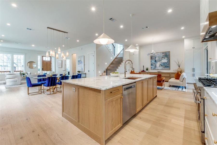 Kitchen featuring pendant lighting, sink, stainless steel appliances, a spacious island, and light brown cabinets