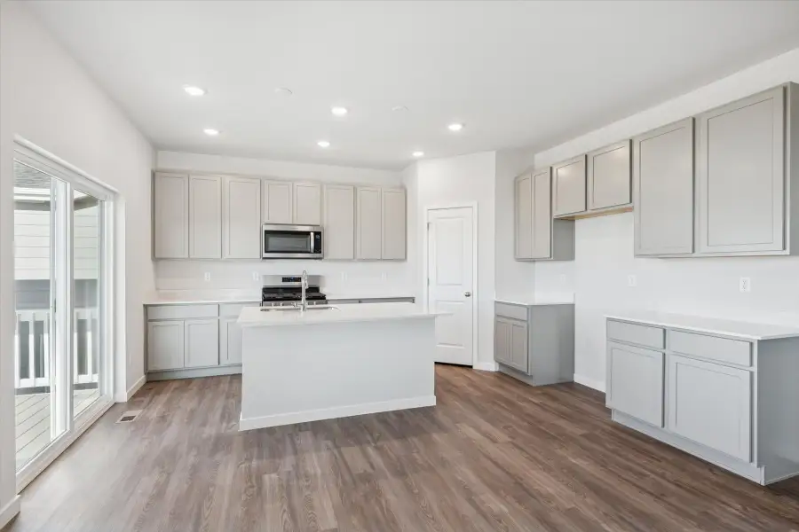 A kitchen with white cabinets.