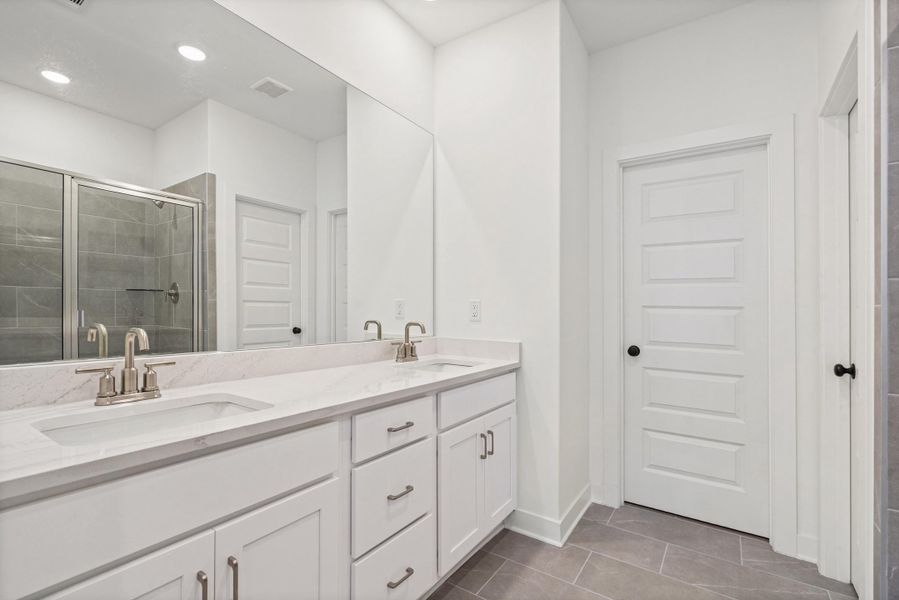 Dual vanity featuring undermount sinks, brushed nickel fixtures, and a light-toned countertop