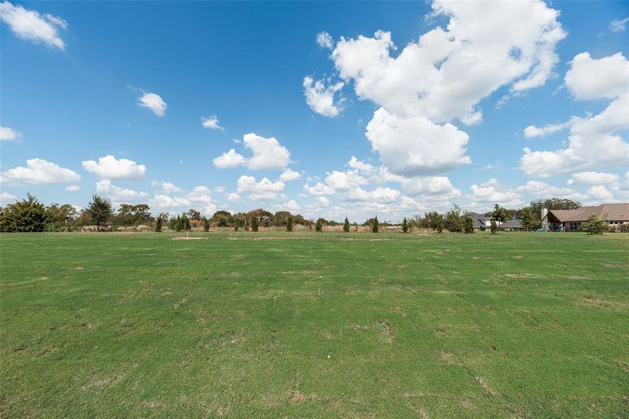 View of community featuring a yard and a view of countryside