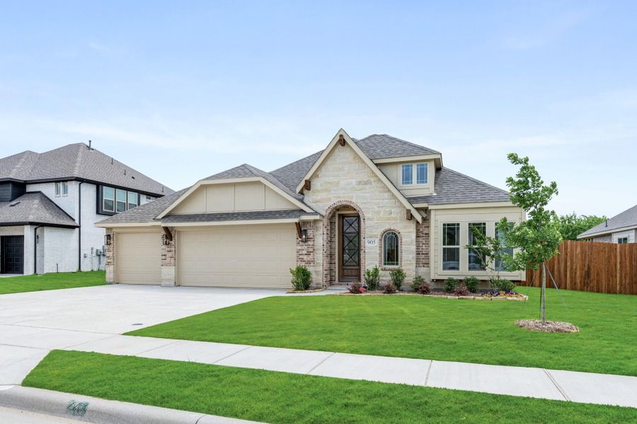 Single-story home with stone and brick exterior, two-car garage, arched entry, and green front lawn Single-story home with stone and brick exterior, two-car garage, arched entry, and green front lawn
