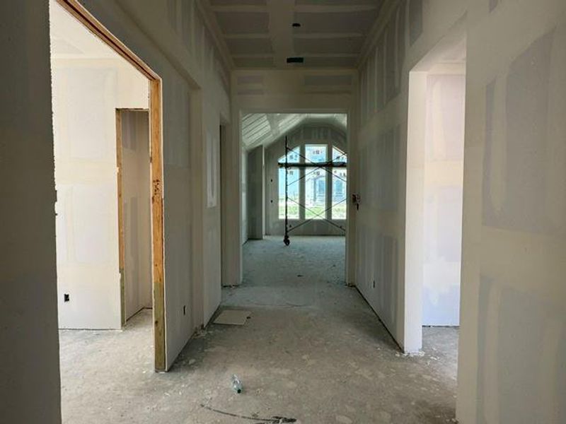 A spacious hallway awaits your personalized touch, offering a glimpse into future living areas through an arched window. A spacious hallway awaits your personalized touch, offering a glimpse into future living areas through an arched window.