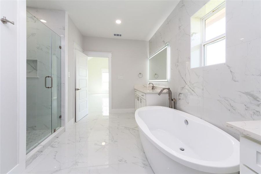 Bathroom featuring vanity, light marble finish flooring, a soaking tub, a marble finish shower, and recessed lighting