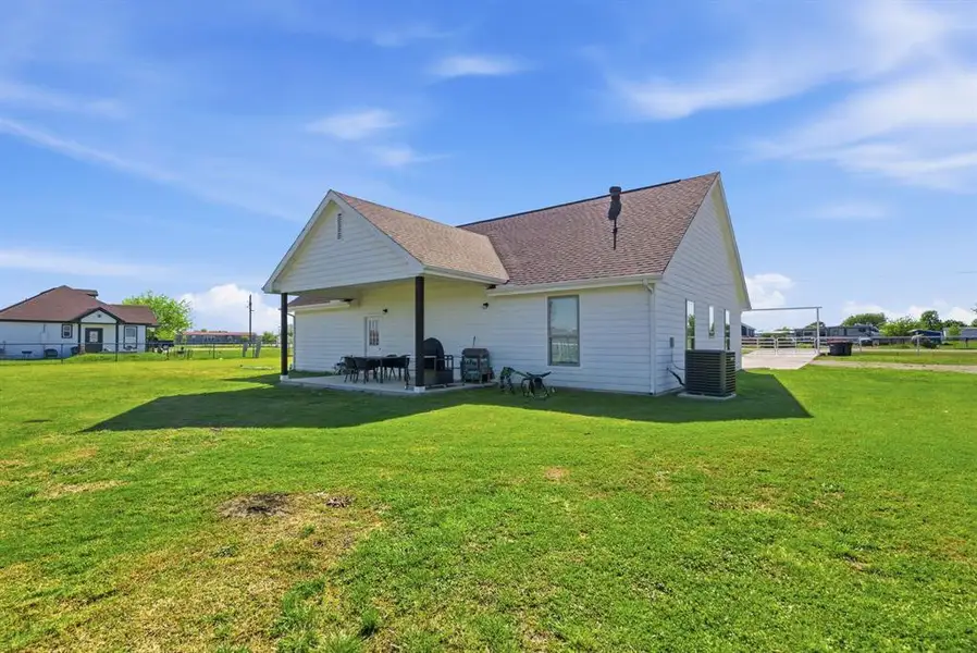 Rear view of property with a patio area and a shingled roof Rear view of property with a patio area and a shingled roof