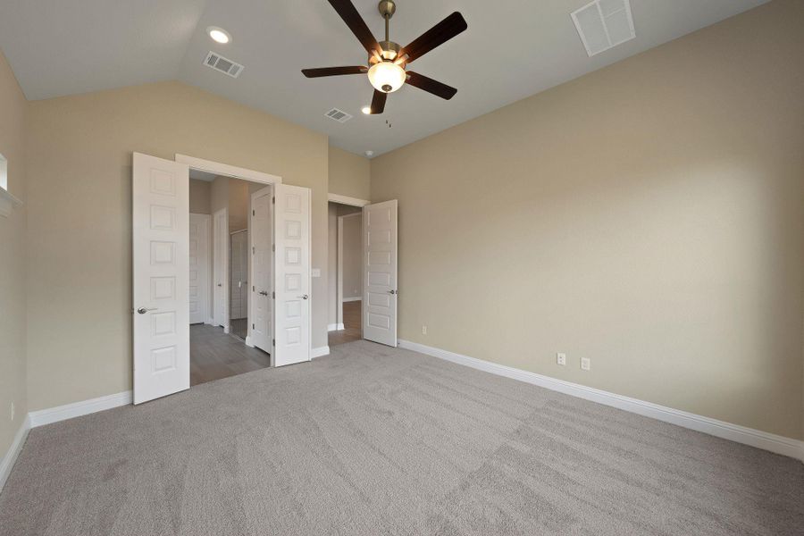Unfurnished bedroom with carpet, lofted ceiling, and ceiling fan