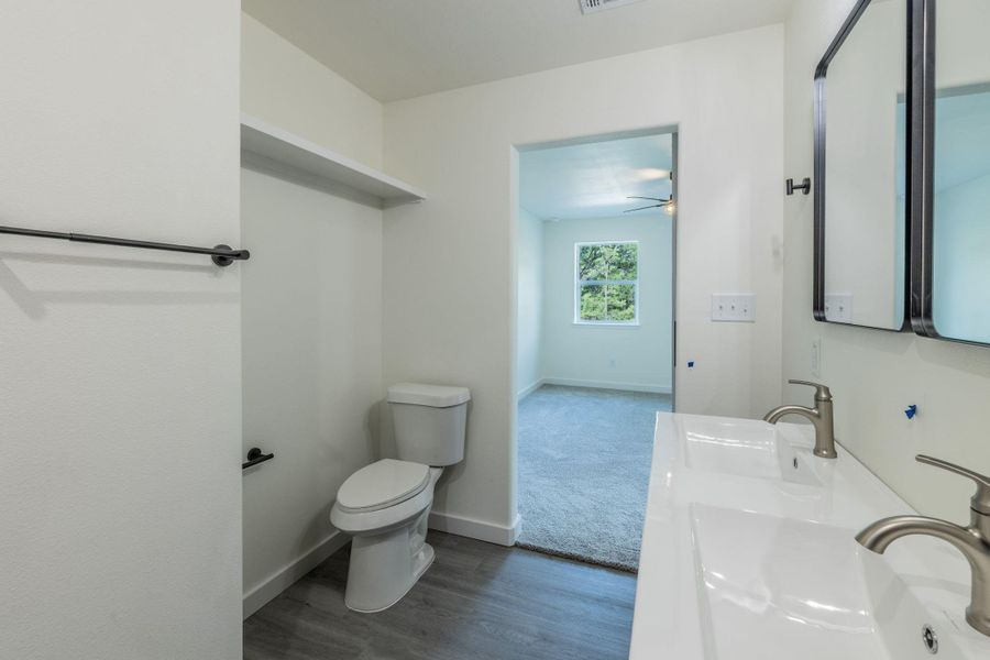 Bathroom featuring a dual vanity with integrated sinks, brushed nickel faucets, and a pair of framed mirrors Bathroom featuring a dual vanity with integrated sinks, brushed nickel faucets, and a pair of framed mirrors
