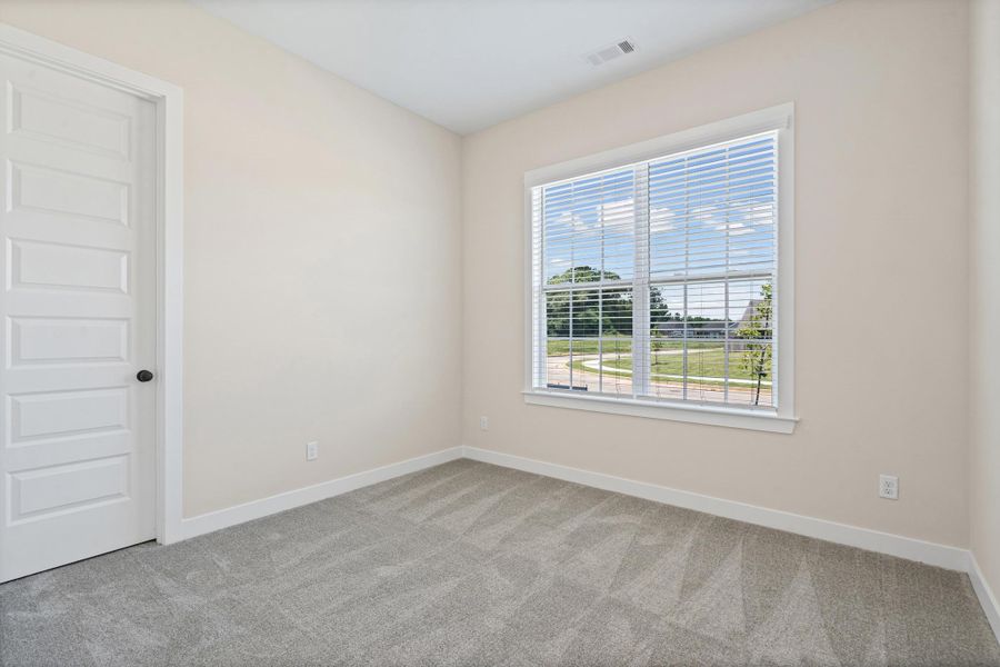 Neutral-toned room featuring a large window with horizontal blinds, providing natural light Neutral-toned room featuring a large window with horizontal blinds, providing natural light
