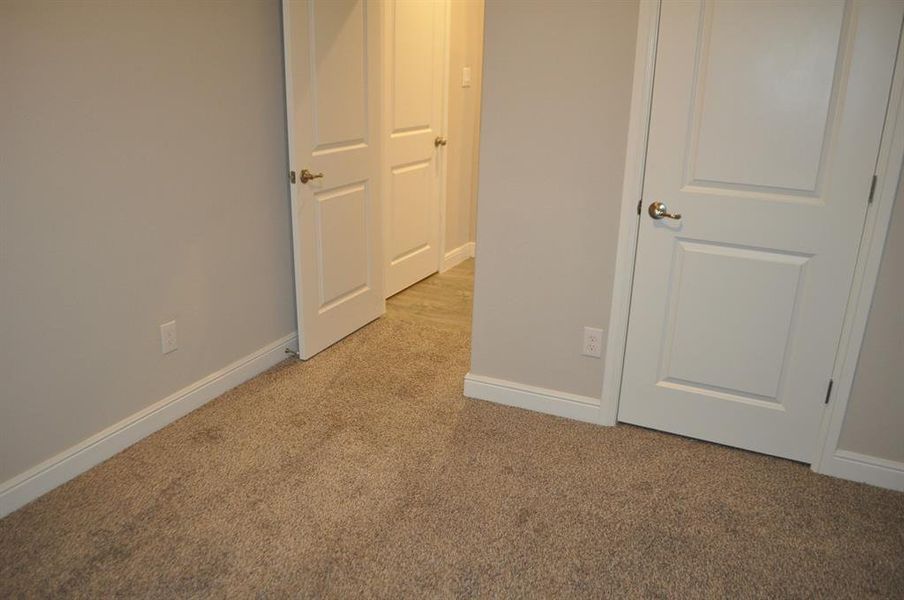 Unfurnished bedroom with light carpet