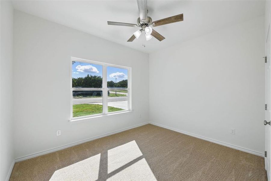 Carpeted empty room featuring baseboards and a ceiling fan Carpeted empty room featuring baseboards and a ceiling fan