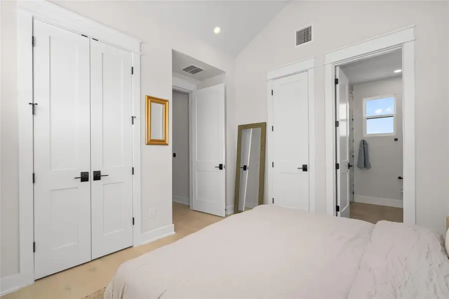 Crisp white walls and light hardwood flooring define this tranquil bedroom with a clear view into an adjoining bath. Crisp white walls and light hardwood flooring define this tranquil bedroom with a clear view into an adjoining bath.