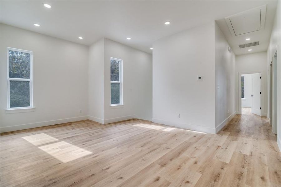 Unfurnished room featuring attic access, light wood-type flooring, recessed lighting, and plenty of natural light
