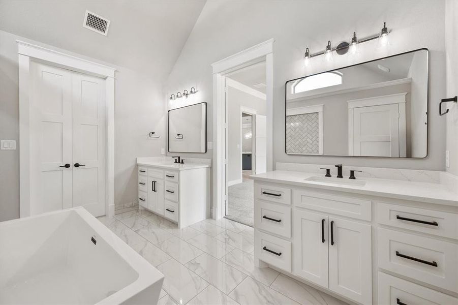Dual vanities with white cabinetry, quartz countertops, and matte black hardware